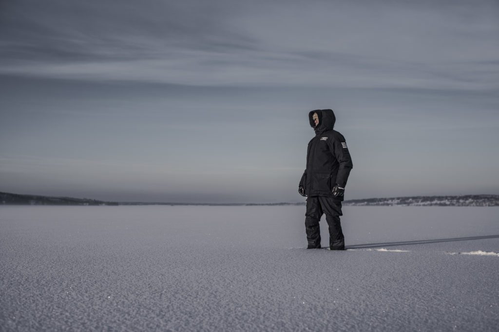 man standing in deep snow wearing black jacket from auk protection